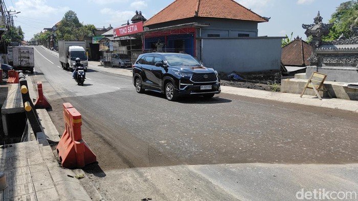 1758605633502-kendaraan-sudah-melintasi-jalan-raya-lukluk-mengwi-badung-yang-belum-diaspal-selasa-2392025-agus-ekadetikbali-1758602423673_169