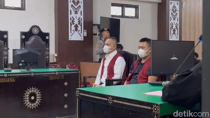 1761586215215-terdakwa-i-made-yogi-purusa-utama-kemeja-putih-dan-i-gde-aris-chandra-widianto-baju-polo-hitam-saat-menjalani-sidang-dakwaan-d-1761556859319_169