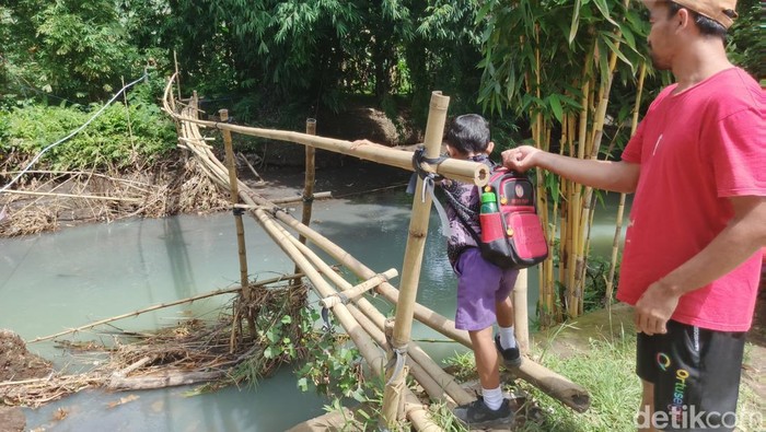 1764760020709-warga-kelurahan-pendem-kabupaten-jembrana-bali-melintasi-jembatan-darurat-yang-sudah-reyot-rabu-3122025-foto-i-putu-adi-budias-1764745240283_169