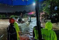 1765731920231-petugas-melakukan-penanganan-genangan-air-setinggi-mata-kaki-yang-berlokasi-di-jalan-utama-desa-pemaron-kecamatankabupaten-bul-1765721802458_43